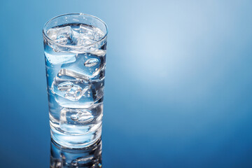 A clear glass filled with chilled water and ice cubes, creating a refreshing and cool drink
