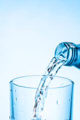 Crystal clear water being poured into a transparent glass, creating refreshing ripples and bubbles