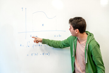 University student explaining integral calculus at whiteboard
