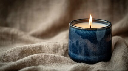 Blue Ceramic Candle Burning on Beige Linen Fabric