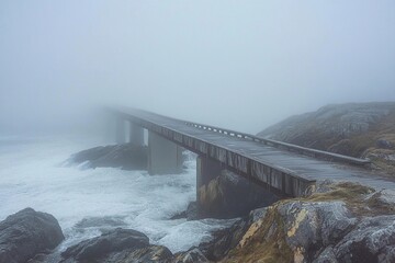 Misty wooden bridge leads to a lonely tree on a rocky island during early morning fog