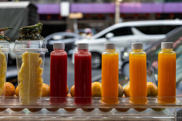 Pressed pomegranate juice at a local thai market. Fruits are cut in half and displayed in fron of the filled juice bottles.
