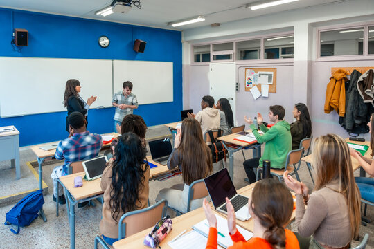 Students clapping in university classroom after presentation of shy student - Powered by Adobe