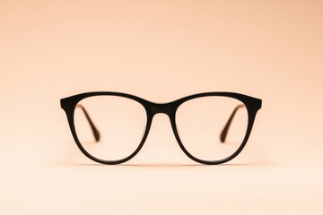 Black framed glasses are presented on a simple neutral backdrop