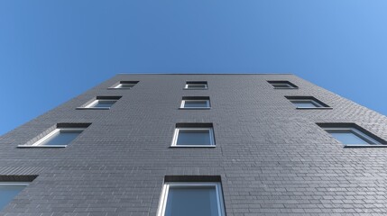 Fototapeta premium Modern grey brick building, clear sky, low angle. Architectural design, real estate