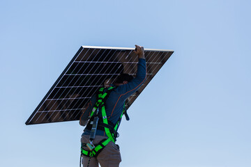 bifacial solar panels being carried on rooftop during solar system installation by electrician