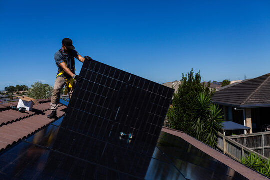 Drill laying on all Black bifacial solar panels on roof during solar system installation