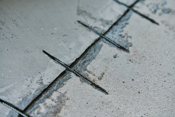 Close-up of concrete surface under repair with reinforcement bars inserted into cracks. Repairing...