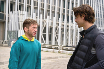 Two men talking outside modern building in brussels