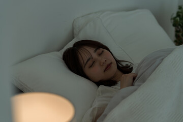 ベッドで眠る若い女性