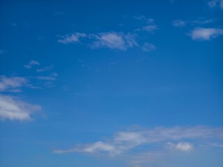 A vast, clear sky adorned with wisps of soft, drifting clouds.