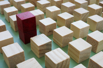 One unique cube stands out among aligned blocks. Individuality and creative thinking.