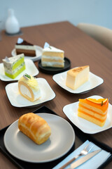 Sweet Symphony: Assortment of gourmet cake slices on individual plates, a visual feast with an enticing array of textures and flavors. Each slice, carefully crafted.
