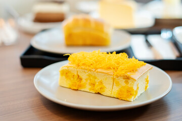 Golden Delight: Captivating overhead shot of traditional golden egg yolk cake, delicately placed on white plates, evoking culinary indulgence. 