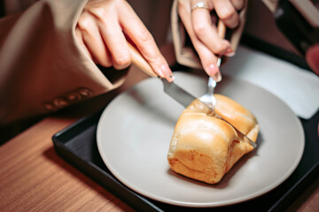 Bread Slicing on a Plate: A close-up shot captures the act of slicing a freshly baked roll of bread on a plate, highlighting the textures and the simple pleasure of enjoying food.
