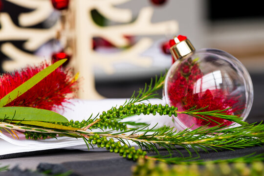 Australian christmas theme table with red native bottlebrush flower in a glass ornament