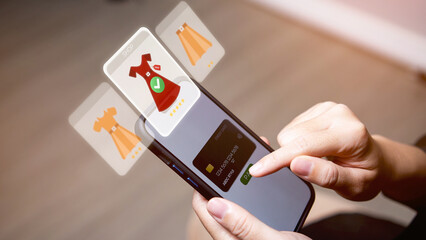 A hand is pressing a credit card to pay on a mobile phone while shopping online.