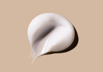 cosmetic smear of creamy texture on a beige background