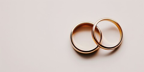 Golden wedding rings on pink background, symbol of marriage