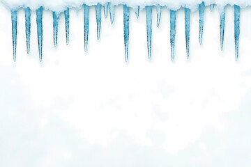 Icy winter scene with a row of icicles hanging from a layer of snow against a bright white background.