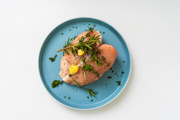 Raw chicken breast marinated with rosemary, garlic and herbs on a white background and vacuum bag.