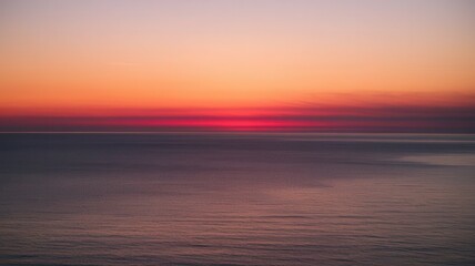 Obraz premium Beautiful sunset over the ocean with colorful sky and calm waters