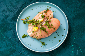 Raw chicken breast marinated with rosemary, garlic and herbs on a white background and vacuum bag.
