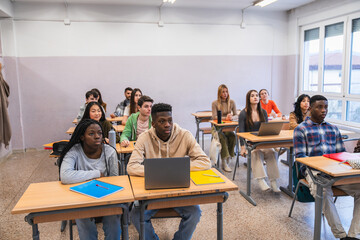 High school students attending class and learning with laptop computers