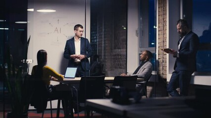 Diverse business team discussing artificial intelligence strategy in a modern office during late hours. Concept of teamwork, innovation, and technology-driven decision-making - Powered by Adobe