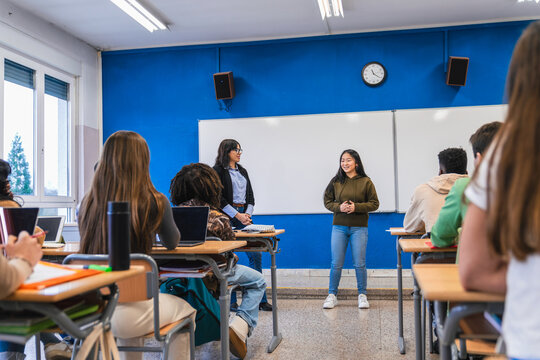 High school student giving presentation to classmates and teacher
