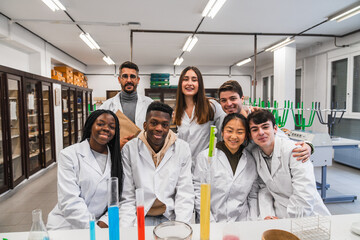 Students and teacher smiling in chemistry lab during experiment