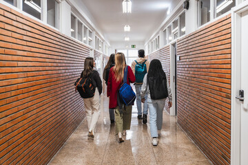 High school students walking down school hallway after class