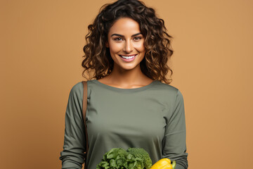 Young smiling cheerful happy cheerful vegetarian woman in her 20s in casual clothes holding vegetables in her hands.