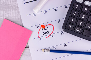 A calendar showing April 15 highlighted in red with a tax form 1099, a calculator, and a pencil...