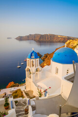 Obraz premium street of traditional greek village Oia of Santorini, with blue domes against Aegan sea and caldera, Greece, web banner format