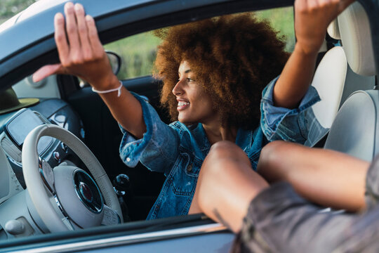 Young woman during road trip, sitting in car