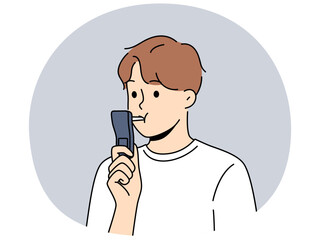 Man blows into breathalyzer to check presence of alcohol in blood and to be safe before car trip. Young guy takes breathalyzer test to prove to police that doesnt have hangover after party.