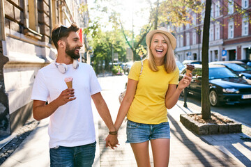 Happy young couple enjoying ice cream in the city