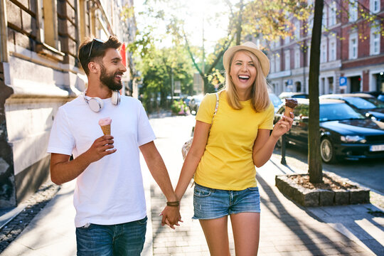 Happy young couple enjoying ice cream in the city