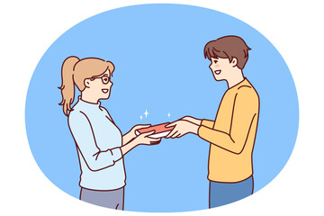 Guy student passes book to girl for concept of school love or joint preparation for exams. Enamored schoolboy and schoolgirl holding book to prepare report on instructions of teacher