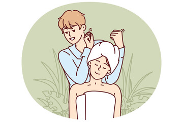 Woman visits massage therapist in SPA salon and sits in towel enjoying relaxing treatments. Man works in SPA center giving shoulder and neck massage to visitor in need of manual procedures