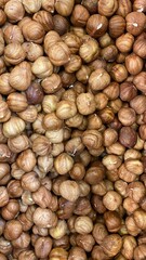 Hazelnuts in natural brown shells piled together creating a textured organic background perfect for healthy snacks and culinary use