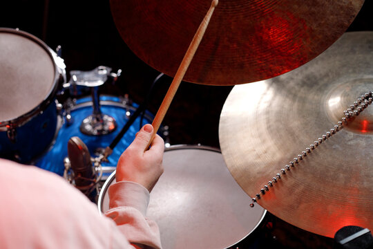 Close up of a musician playing the drums with focus on cymbals and drumsticks