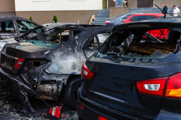 A cropped front view of a burned and abandoned rusty cars