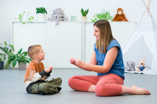 Baby Sign Language. Nonverbal child learning to sign with the help of a speech therapist. Child therapy, neurodiversity, learning difficulty, developmental disability.