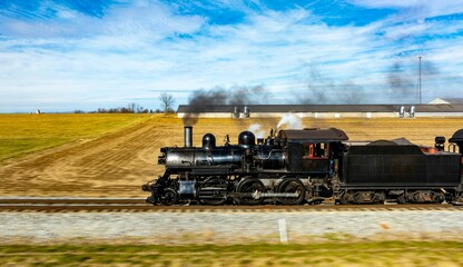 Vintage steam locomotive in rural landscape.