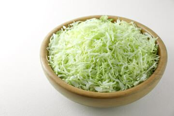 Fresh shredded cabbage on light table, closeup