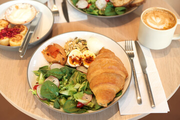 Tasty breakfast. Different meals and coffee served on wooden table in cafe, closeup