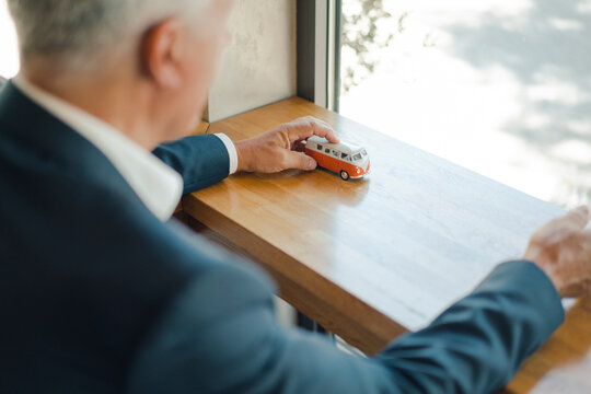 Senior businessman with minibus model in a cafe