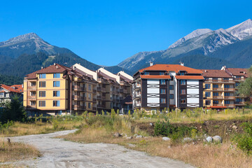 Wooden chalet hotel houses and summer mountains panorama in bulgarian ski resort Bansko, Bulgaria